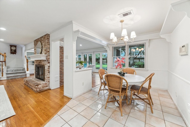 13307 Westport Ln, Houston, TX 77079 - dining space with stairs, a chandelier, a fireplace, light tile patterned floors, and crown molding
