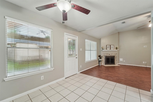 19115 Forest Ridge Dr, Magnolia, TX 77355 - unfurnished living room featuring ceiling fan, vaulted ceiling, light tile patterned flooring, and a fireplace with flush hearth