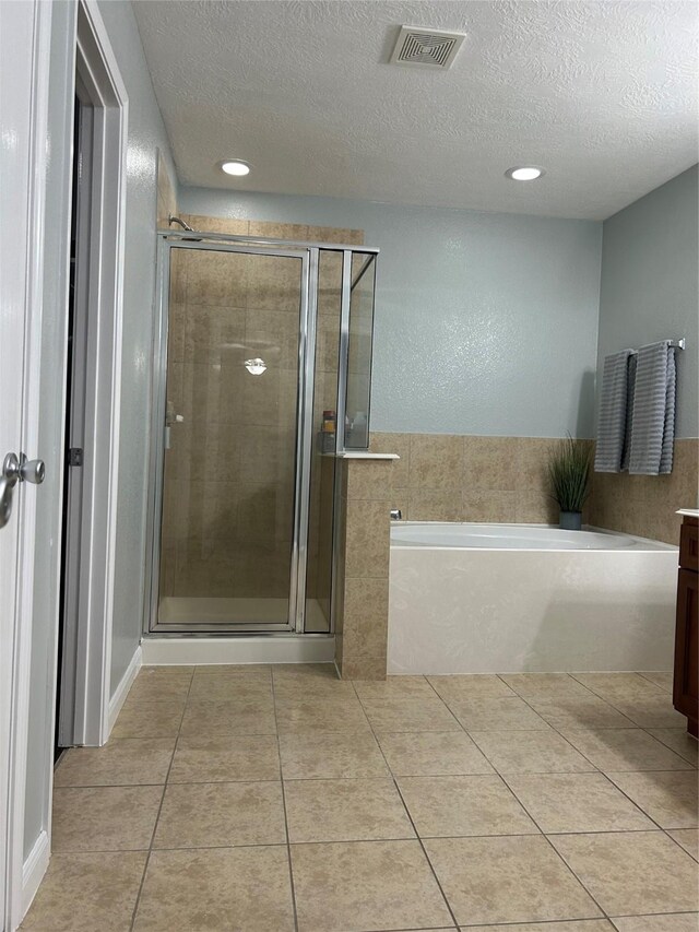 11618 Wren Crossing Dr, Houston, TX 77038 - full bath with tile patterned floors, a bath, a textured ceiling, a shower stall, and vanity