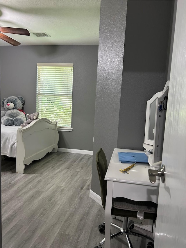 11618 Wren Crossing Dr, Houston, TX 77038 - bedroom featuring wood finished floors, a desk, a ceiling fan, a textured wall, and a textured ceiling