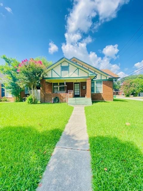 1502 Godwin St, Houston, TX 77023 - view of front facade with covered porch, a front yard, and brick siding