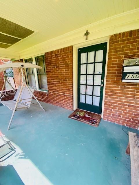 1502 Godwin St, Houston, TX 77023 - doorway to property with covered porch and brick siding