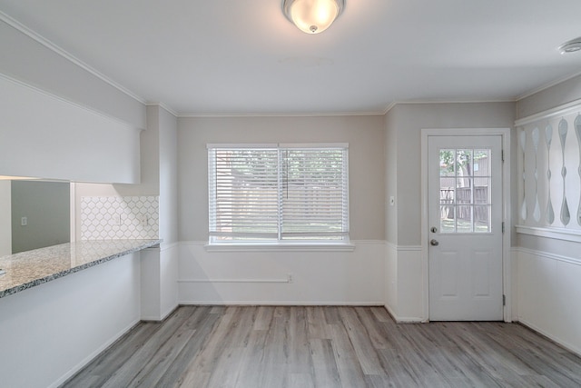 206 Enchanted River Dr, Spring, TX 77388 - unfurnished dining area with light wood finished floors, healthy amount of natural light, and crown molding