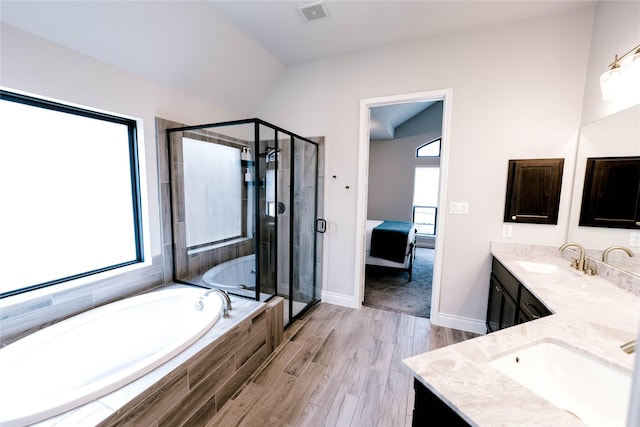 3319 Pleasant Hollow Ln, Houston, TX 77365 - bathroom featuring double vanity, a bath, a shower stall, wood finished floors, and ensuite bathroom