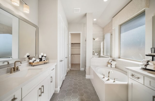 16035 Tangled Vine Ln, Conroe, TX 77302 - full bathroom with vanity, a bath, a walk in closet, a tile shower, and tile patterned flooring