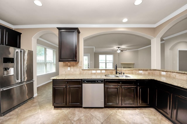 12131 Cove Ridge Ln, Cypress, TX 77433 - kitchen with appliances with stainless steel finishes, ceiling fan, plenty of natural light, arched walkways, and crown molding