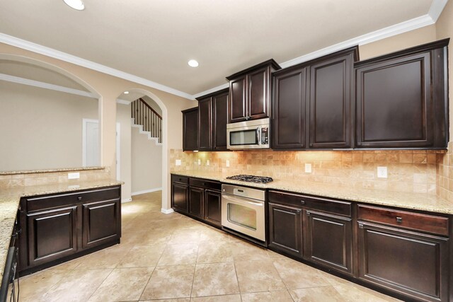 12131 Cove Ridge Ln, Cypress, TX 77433 - kitchen with stainless steel appliances, light stone countertops, recessed lighting, tasteful backsplash, and ornamental molding