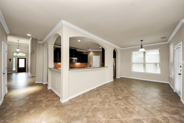 12131 Cove Ridge Ln, Cypress, TX 77433 - kitchen with stainless steel microwave, plenty of natural light, dark cabinets, ornamental molding, and recessed lighting