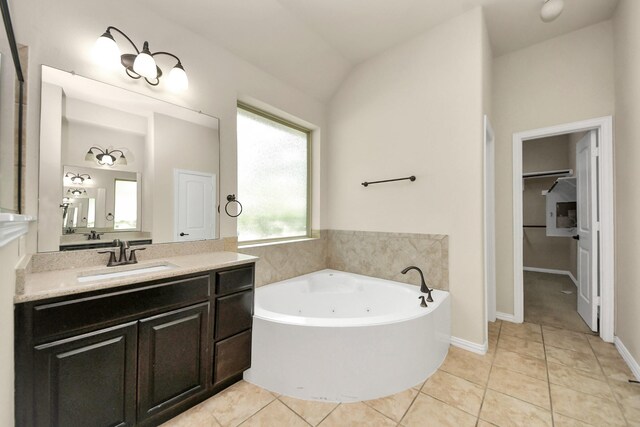 12131 Cove Ridge Ln, Cypress, TX 77433 - bathroom featuring a jetted tub, vanity, tile patterned flooring, and a walk in closet