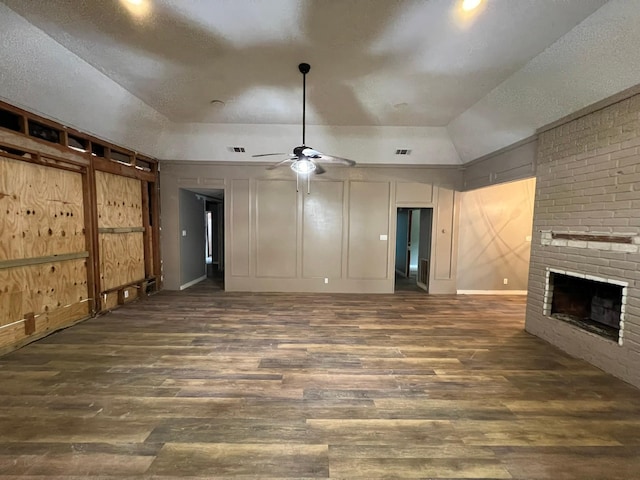 17506 Rustington Dr, Spring, TX 77379 - unfurnished living room with lofted ceiling, a brick fireplace, wood finished floors, a ceiling fan, and a textured ceiling