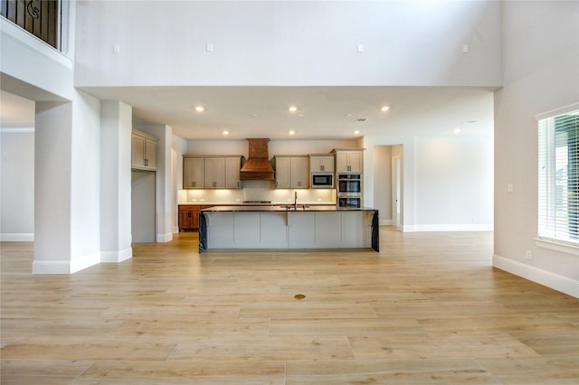 3242 N Upland St, Katy, TX 77493 - kitchen featuring built in microwave, custom exhaust hood, a towering ceiling, double oven, and light wood-type flooring