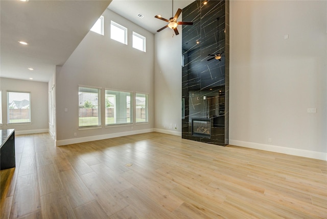 3242 N Upland St, Katy, TX 77493 - unfurnished living room with ceiling fan, a towering ceiling, wood finished floors, recessed lighting, and a fireplace