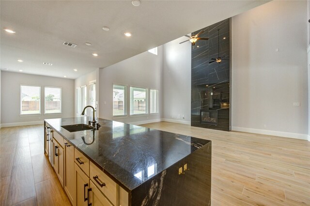 3242 N Upland St, Katy, TX 77493 - kitchen featuring open floor plan, dark stone counters, an island with sink, recessed lighting, and light wood-style floors