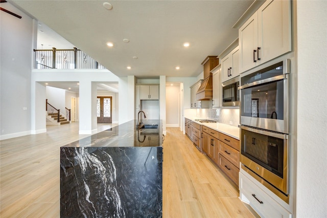 3242 N Upland St, Katy, TX 77493 - kitchen featuring stainless steel appliances, light wood-style floors, recessed lighting, dark stone countertops, and a large island with sink