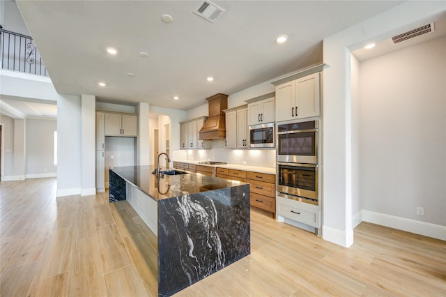 3242 N Upland St, Katy, TX 77493 - kitchen featuring stainless steel appliances, premium range hood, recessed lighting, a spacious island, and light wood-style floors