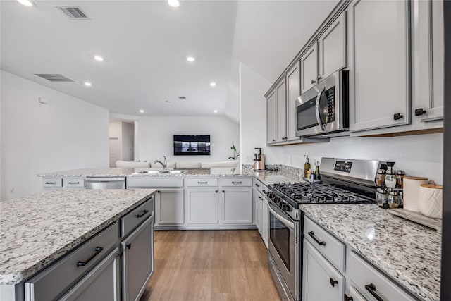 24107 Avocet Creek Rd, Katy, TX 77493 - kitchen with appliances with stainless steel finishes, gray cabinets, light wood-style floors, recessed lighting, and light stone counters