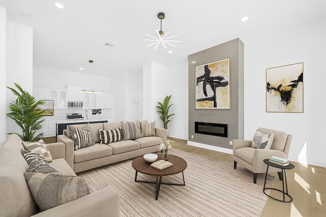 2122 Oatfield Dr, Houston, TX 77018 - living area with recessed lighting, light wood finished floors, a large fireplace, and a chandelier