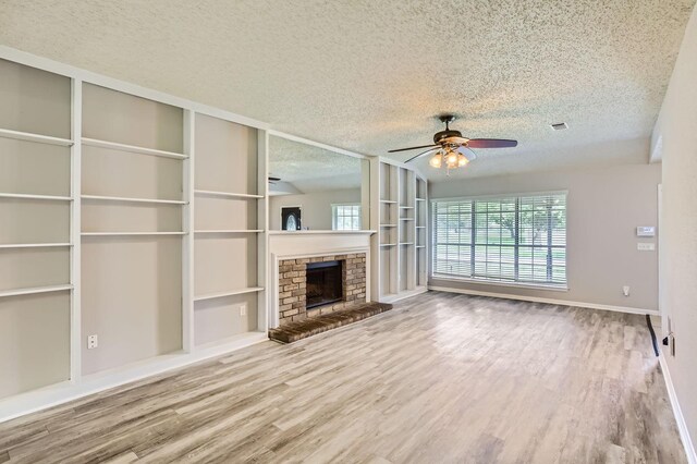 11910 Yearling Dr, Houston, TX 77065 - unfurnished living room with a ceiling fan, a textured ceiling, wood finished floors, a fireplace, and built in features
