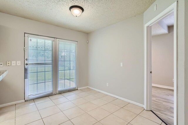 11910 Yearling Dr, Houston, TX 77065 - empty room with a textured ceiling and light tile patterned floors