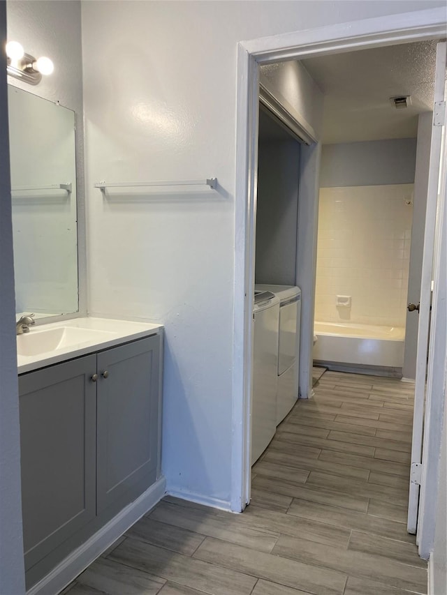 8703 Victorian Village Dr Unit 8703, Houston, TX 77071 - full bath with independent washer and dryer, vanity, wood tiled floors, and a bath