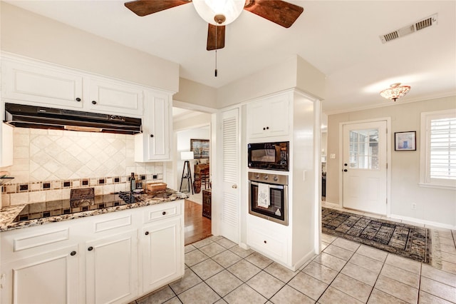 2602 Briarbrook Dr, Houston, TX 77042 - kitchen with black appliances, under cabinet range hood, light tile patterned floors, tasteful backsplash, and white cabinetry