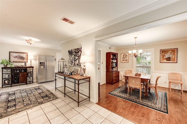 2602 Briarbrook Dr, Houston, TX 77042 - dining space with a chandelier, ornamental molding, a wainscoted wall, tile patterned floors, and a decorative wall