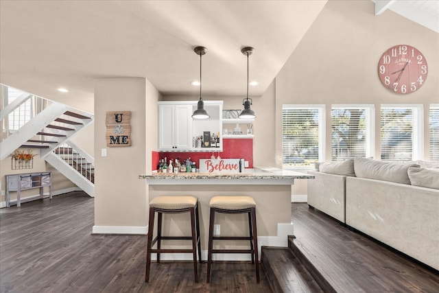 8307 Amber Cove Dr, Atascocita, TX 77346 - kitchen with white cabinetry, a breakfast bar area, dark wood finished floors, open shelves, and decorative light fixtures
