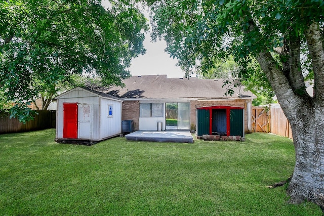 6915 Jeb Stuart Dr, Richmond, TX 77469 - rear view of property featuring a storage unit, brick siding, a fenced backyard, roof with shingles, and a patio area