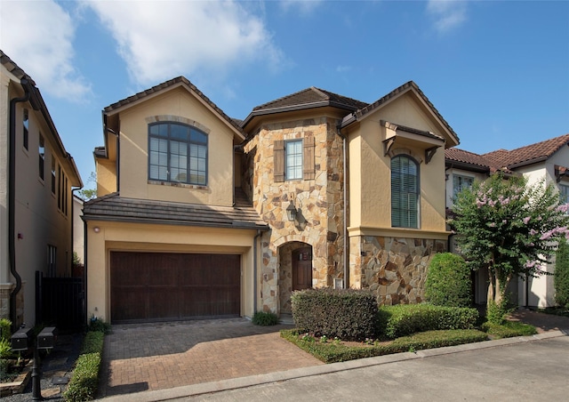 25 N Creekside Ct, Houston, TX 77055 - view of front of property with stone siding, an attached garage, stucco siding, decorative driveway, and a tiled roof