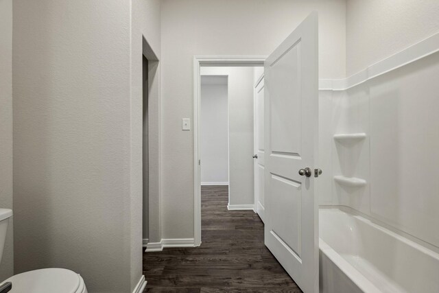 10419 Red Cardinal Dr, Houston, TX 77328 - bathroom with toilet, wood finished floors, washtub / shower combination, and baseboards
