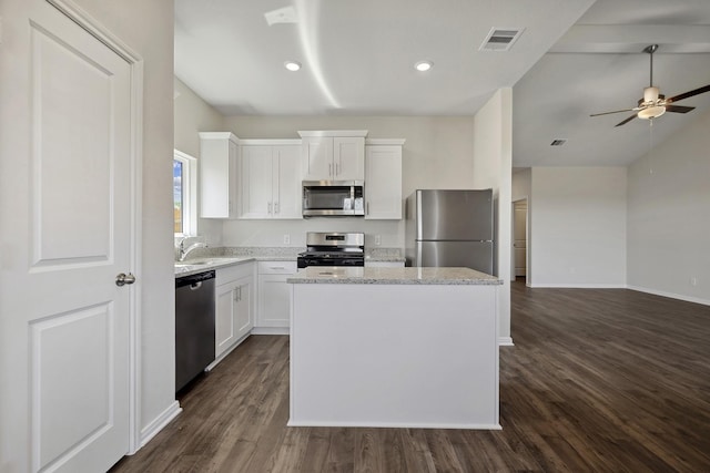 10419 Red Cardinal Dr, Houston, TX 77328 - kitchen featuring appliances with stainless steel finishes, a kitchen island, dark wood-type flooring, ceiling fan, and white cabinetry