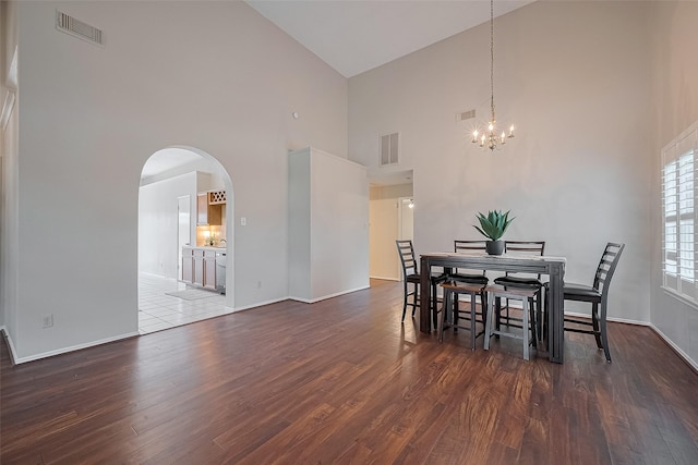 5814 N Magazine Cir, Houston, TX 77084 - dining area with high vaulted ceiling, arched walkways, a chandelier, and wood finished floors
