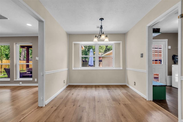 17427 Pinewood Forest Dr, Spring, TX 77379 - unfurnished dining area featuring light wood-style floors, washer / dryer, and a chandelier