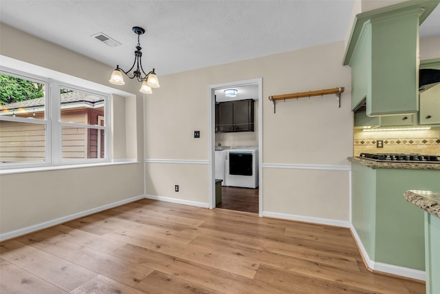 17427 Pinewood Forest Dr, Spring, TX 77379 - unfurnished dining area with washer / clothes dryer, light wood-style flooring, and a chandelier
