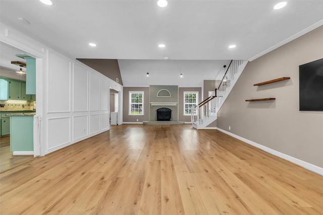 17427 Pinewood Forest Dr, Spring, TX 77379 - unfurnished living room featuring a brick fireplace, light wood finished floors, recessed lighting, and stairway