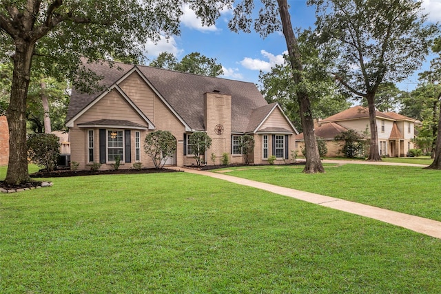 17427 Pinewood Forest Dr, Spring, TX 77379 - traditional-style house with a chimney, a front yard, a shingled roof, and brick siding
