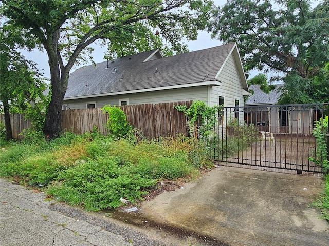 3022 Mcilhenny St, Houston, TX 77004 - view of side of property with a shingled roof and a gate