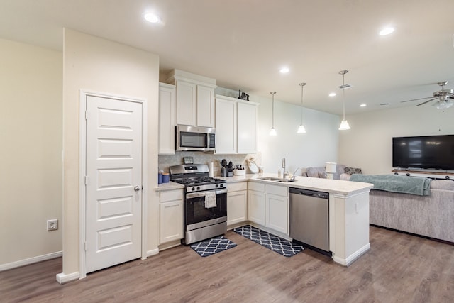 5529 Evanston Ln, Pasadena, TX 77505 - kitchen with appliances with stainless steel finishes, open floor plan, light wood finished floors, white cabinetry, and recessed lighting