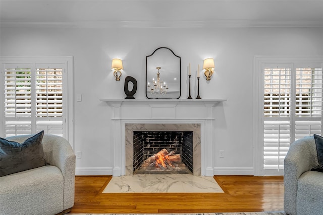2539 Addison Rd, Houston, TX 77030 - living room featuring ornamental molding, a premium fireplace, wood finished floors, and a chandelier