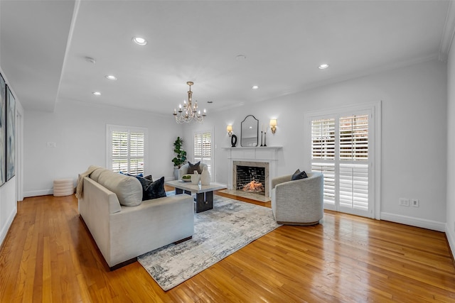 2539 Addison Rd, Houston, TX 77030 - living room featuring recessed lighting, light wood finished floors, a tiled fireplace, a chandelier, and crown molding