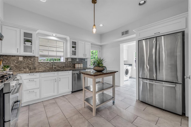 2539 Addison Rd, Houston, TX 77030 - kitchen with stainless steel appliances, washer / clothes dryer, white cabinetry, tasteful backsplash, and recessed lighting