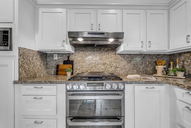 2539 Addison Rd, Houston, TX 77030 - kitchen with gas stove, under cabinet range hood, white cabinets, and decorative backsplash