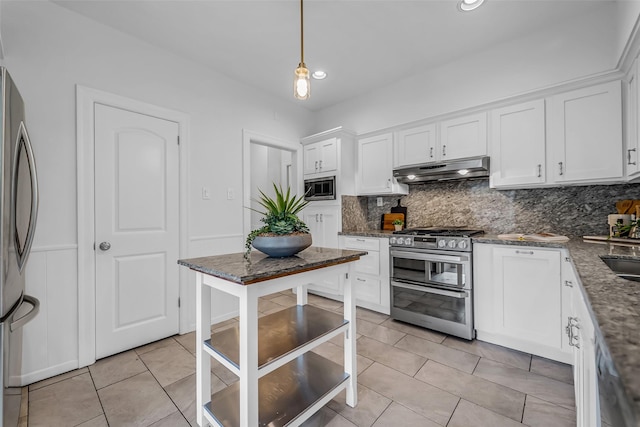 2539 Addison Rd, Houston, TX 77030 - kitchen with stainless steel appliances, under cabinet range hood, backsplash, white cabinets, and recessed lighting