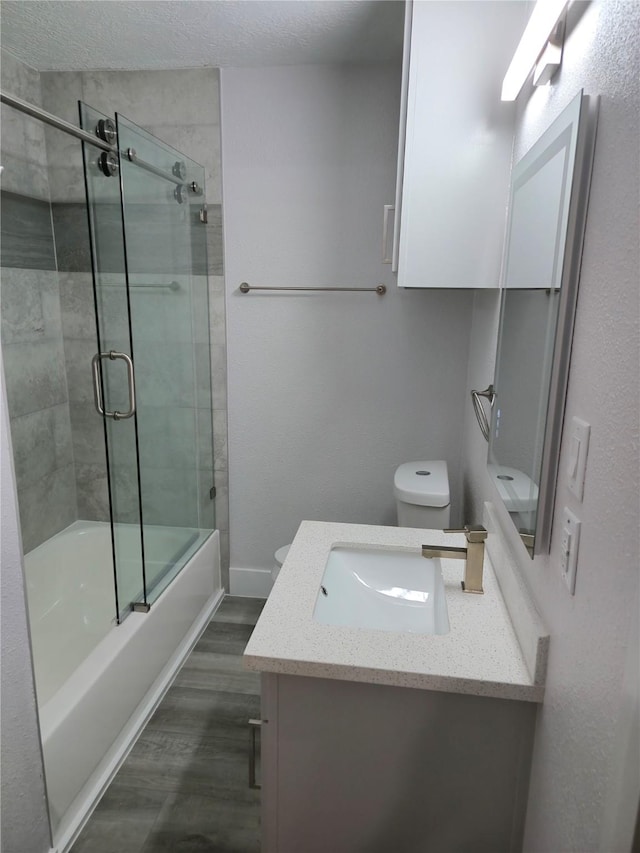 4104 Idaho St, Houston, TX 77021 - bathroom with vanity, wood finished floors, enclosed tub / shower combo, and a textured ceiling