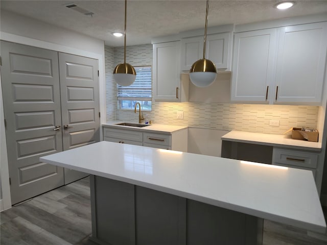 4104 Idaho St, Houston, TX 77021 - kitchen with tasteful backsplash, hanging light fixtures, a textured ceiling, light countertops, and wood finished floors