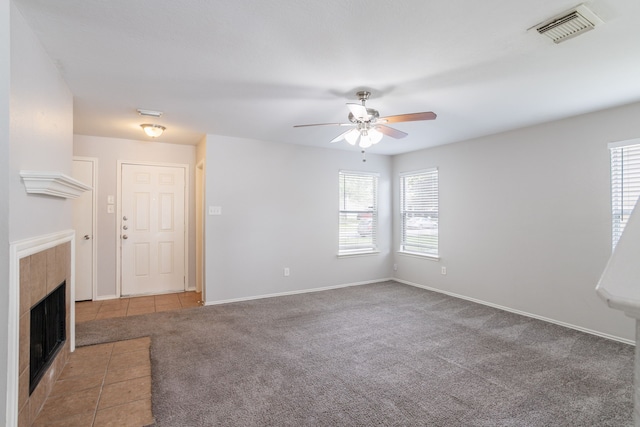 12026 Madison Oak St, Houston, TX 77038 - unfurnished living room featuring ceiling fan, plenty of natural light, a tiled fireplace, and carpet floors