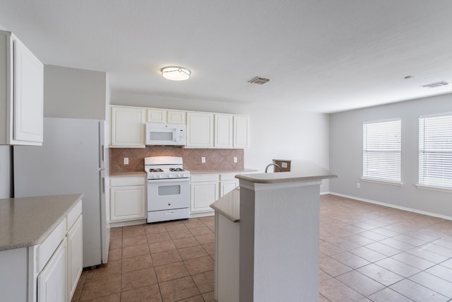 12026 Madison Oak St, Houston, TX 77038 - kitchen with white appliances, tile patterned floors, tasteful backsplash, and white cabinetry