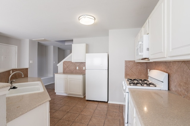12026 Madison Oak St, Houston, TX 77038 - kitchen featuring white appliances, backsplash, white cabinets, and light tile patterned floors