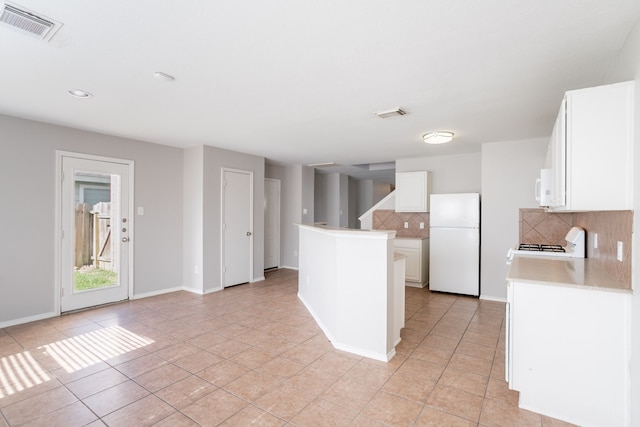 12026 Madison Oak St, Houston, TX 77038 - kitchen with white appliances, tasteful backsplash, light tile patterned floors, white cabinets, and recessed lighting