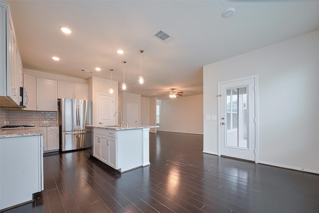 3414 Signor Dr, Houston, TX 77025 - kitchen featuring appliances with stainless steel finishes, ceiling fan, tasteful backsplash, light stone countertops, and white cabinets